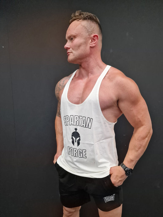 Man wearing a white tank top with visible branding on a dark background